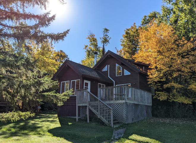 Exterior of two story Chickadee cabin, with the sun rising.