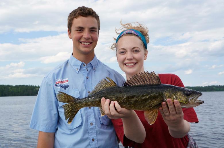 Brother and sister fisherpeople show off a perfect walleye