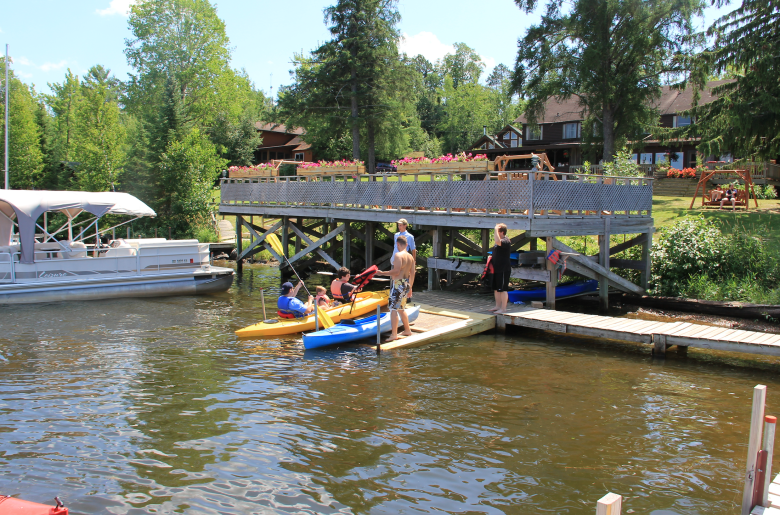 Pehrson Lodge dock staff help guests launch kayaks