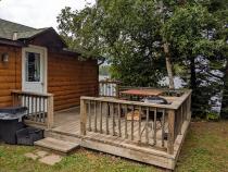 Sunbeam's entrance with deck, picnic table, and charcoal grill.