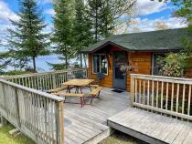 Deck area with a picnic table and charcoal grill.
