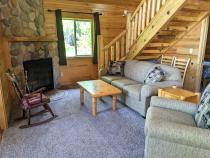Living room with couch, recliner, and wood burning fireplace.